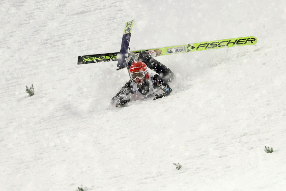 Markus Eisenbichler schlittert nach seinem Sturz die Piste hinab.