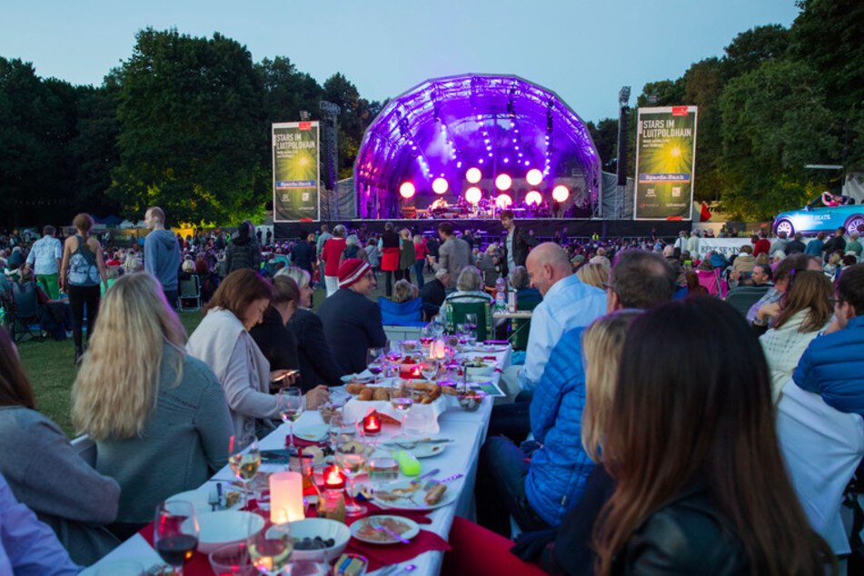 Besucher des Open Airs in Nürnberg sitzen an Tischen. In diesem Sommer dürfen draußen nur 400 Personen zusammen kommen. (Archivbild)