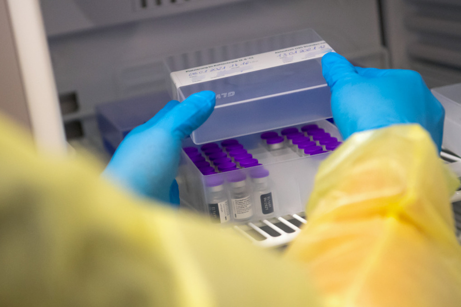 Eine Mitarbeiterin vom bayerischen roten Kreuz (BRK) holt Ampullen des Impfstoffs von Biontech/Pfizer gegen das Coronavirus SARS-CoV-2 im Impfzentrum aus einem speziellen Kühlschrank.