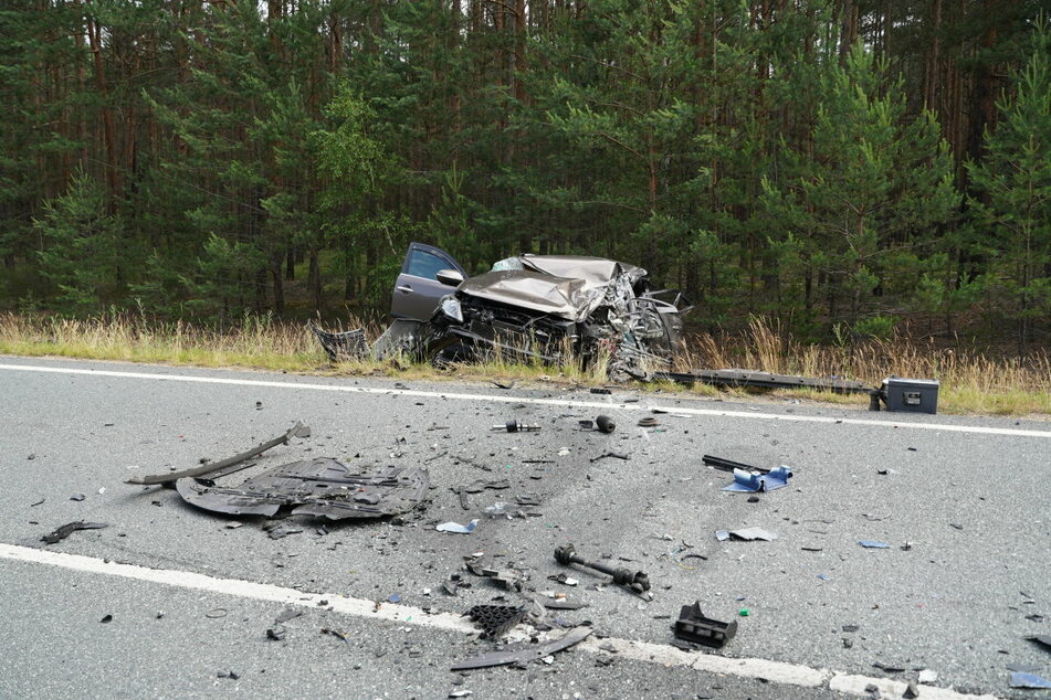 Das Wrack des schwarzen Kia liegt im Straßengraben.