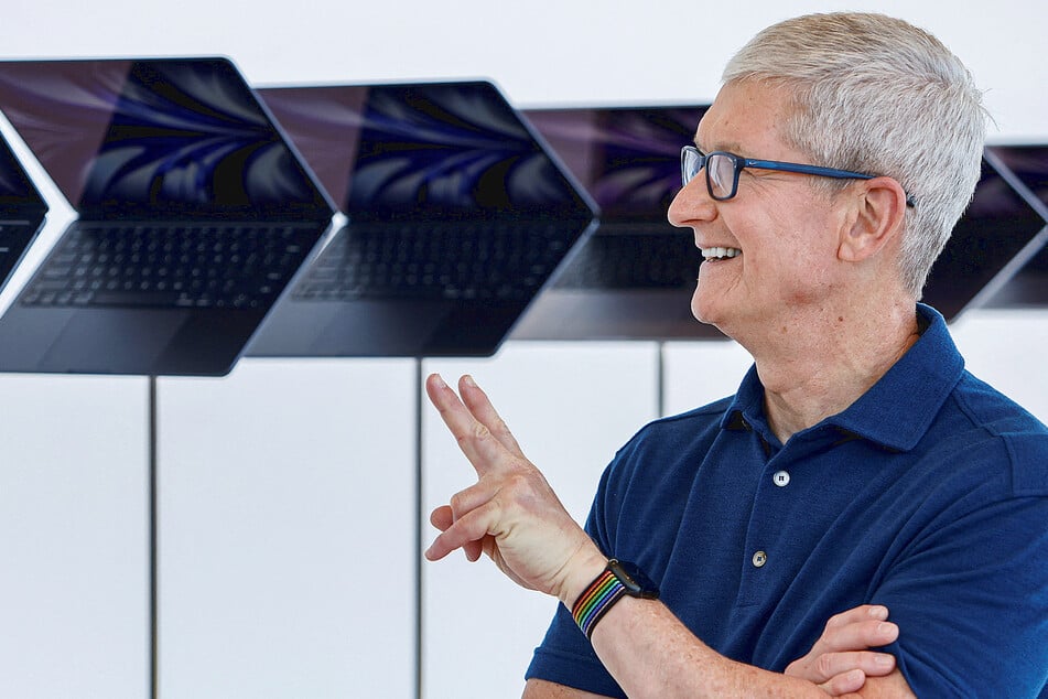 Tim Cook throws a peace sign while posing with the new MacBook Air.