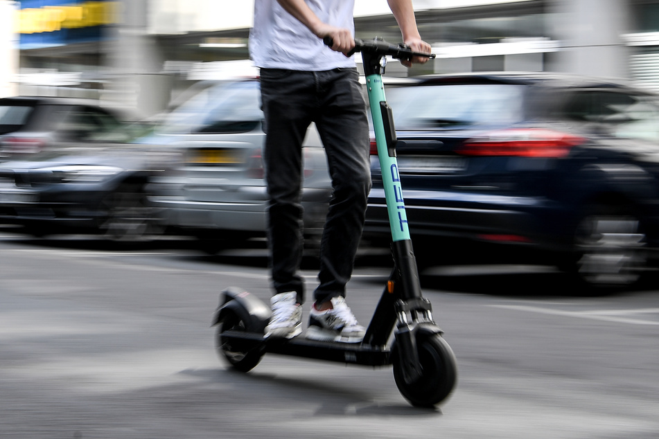 Ein Mann fährt mit einem E-Tretroller des Anbieters Tier.