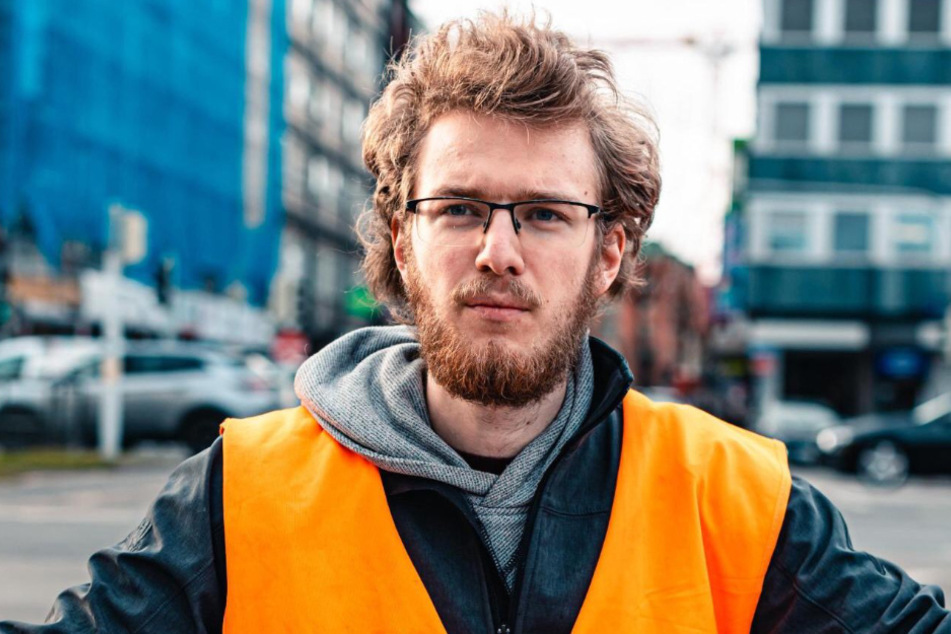 Daniel Eckert gehört der Letzten Generation an und sitzt auf der Straße, um sich "der bevorstehenden Klimakatastrophe" entgegenzustellen.