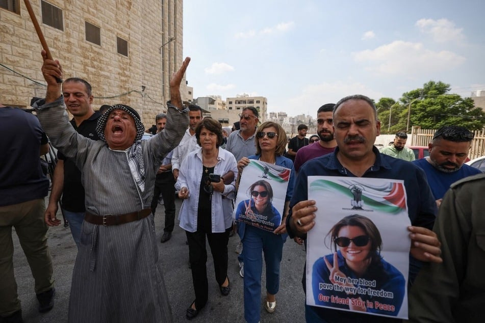 Palestinians and international activists lift portraits of slain Turkish-American citizen Aysenur Ezgi Eygi as they arrive for her final farewell at the Rafidia hospital morgue in Nablus in the occupied West Bank on September 8, 2024.