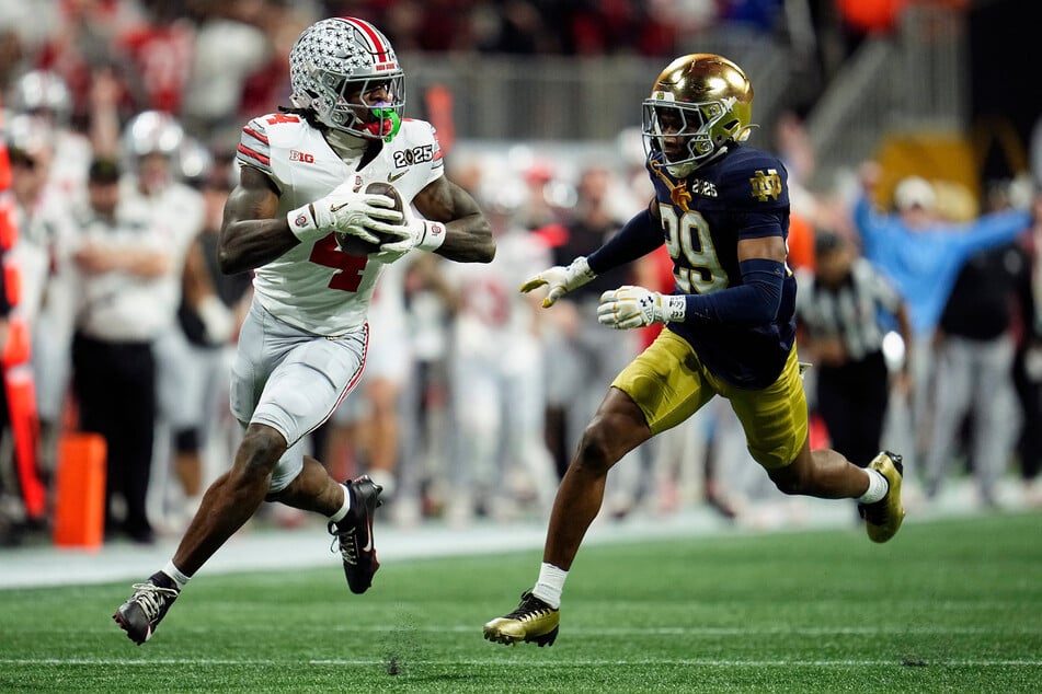 Ohio State Buckeyes wide receiver Jeremiah Smith (l.) makes a catch against Notre Dame Fighting Irish cornerback Christian Gray in the fourth quarter during the College Football Playoff National Championship.