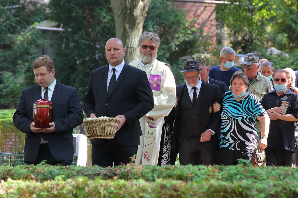 Pastor Conrad Herold mit Trauergästen auf dem Weg zum Grab.