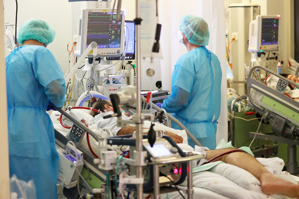 Zwei Intensivpfleger versorgen einen Covid-19-Patienten auf der Intensivstation der Leipziger Uniklinik. Insgesamt 1520 Intensivbetten sind im Freistaat aktuell mit Corona-Patienten belegt.