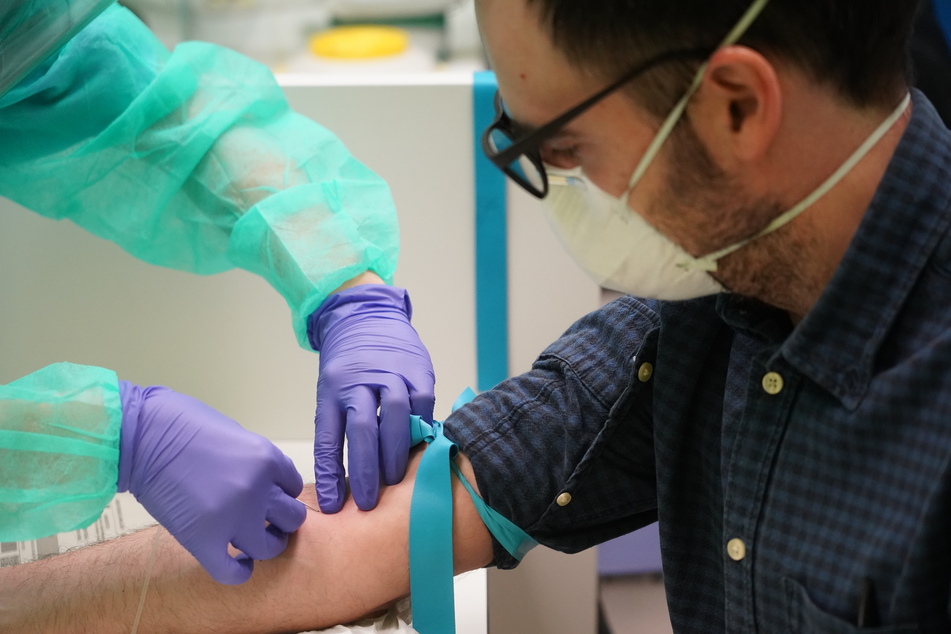 Eine Krankenschwester nimmt einem Patienten, bei dem Covid-19 diagnostiziert wurde und der zuvor nicht getestet wurde, Blut ab.