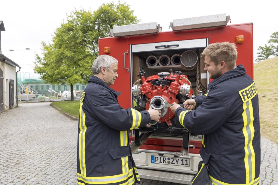 Festungsfeuerwehrchef Ulli Müller und Mitarbeiter Nico Petrich (28) holen die Pumpe aus dem Wagen.