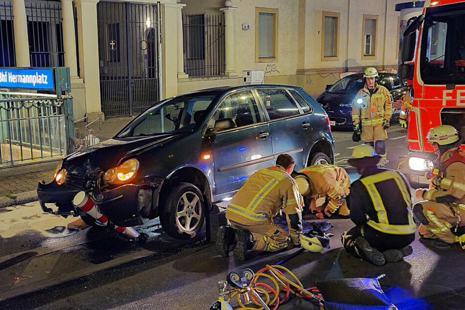Feuerwehrleute betrachten den Unfallschaden.
