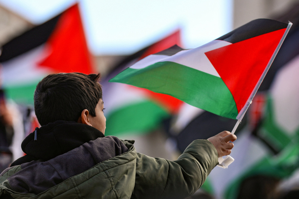 A young boy holds a Palestinian flag during the National March on Washington for Gaza on January 13, 2024.