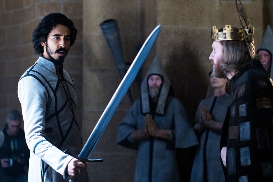 Gawain (Dev Patel, 31, l.) bekommt von seinem Onkel, dem König (Sean Harris, 55, v.-r.), dessen Schwert für den Kampf überreicht.