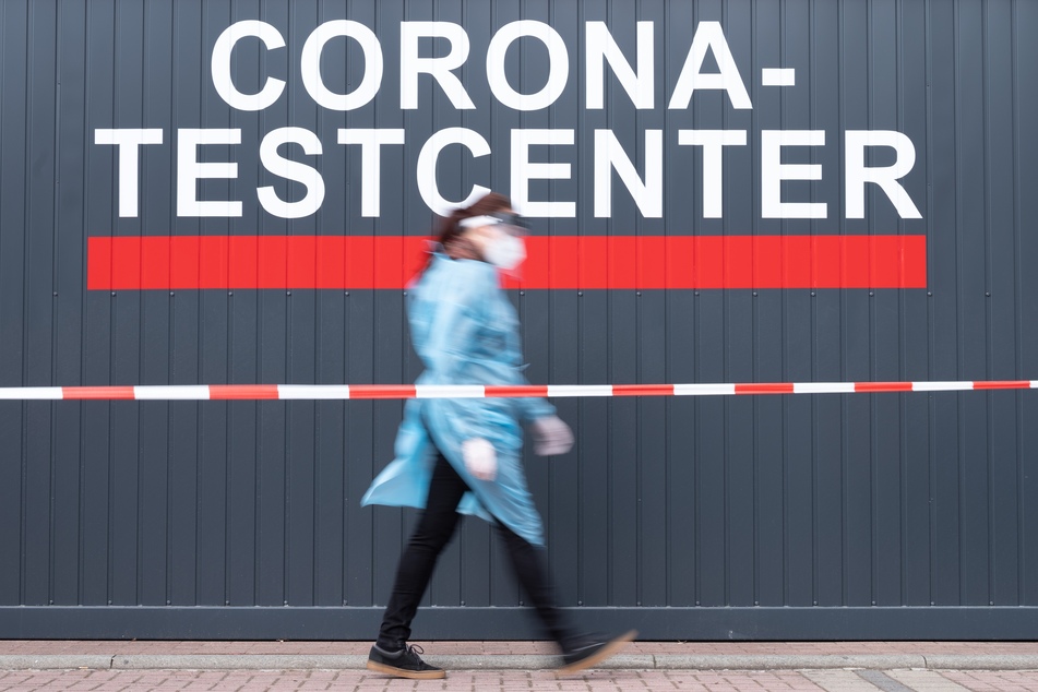 Sachsen, Dresden: Louise Walewski, Mitarbeiterin hectas Sicherheitsdienste GmbH, geht vor einem Corona-Testcenter entlang.