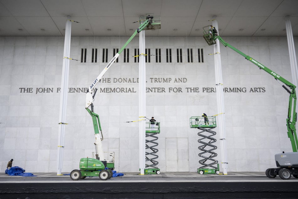 Workers are seen outside the John F. Kennedy Memorial Center for the Performing Arts as they update the signage after the center was renamed in honor of Donald Trump on December 19, 2025.