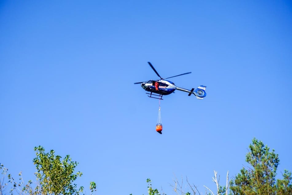 Erneut hilft ein Hubschrauber der Landespolizei bei den Löscharbeiten.