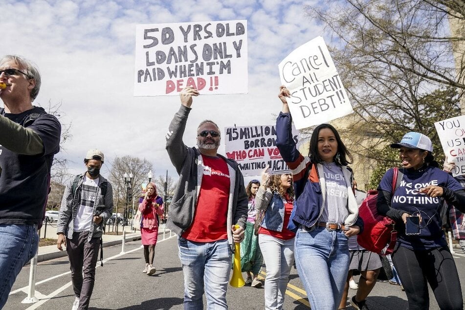 Protesters march past the US Department of Education to demand full student debt cancelation.