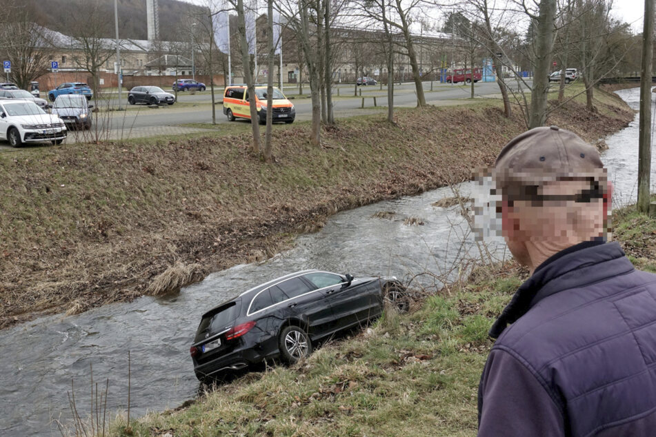 Bevor der Wagen ganz in den Fluss "Gottleuba" stürzte, kam er schräg am Abhang zum Stehen. Der Fahrer (84, r.) konnte sich über die Beifahrertür retten.