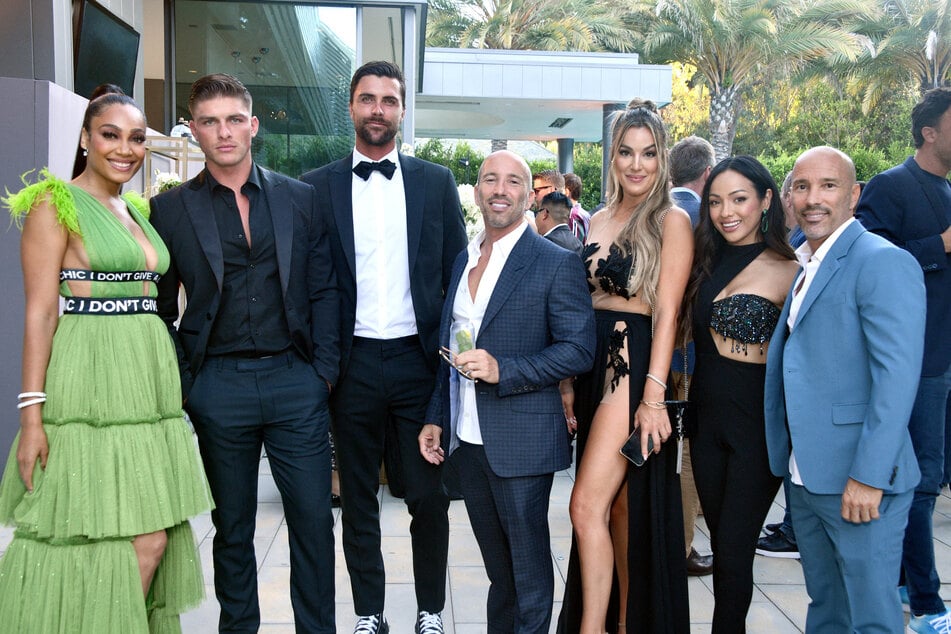 The cast of Selling the OC (from l to r) Brandi Marshall, Austin Victoria, Tyler Stanaland, Jason Oppenheim, Alexandra "Alex" Hall, Lauren Brito, and Brett Oppenheim pose at Netflix's Open House Cocktail Party.