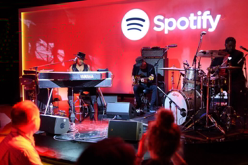 D'Angelo (L), American R&B and neo soul singer-songwriter, plays for reporters at a Spotify news conference May 20, 2015 in New York.