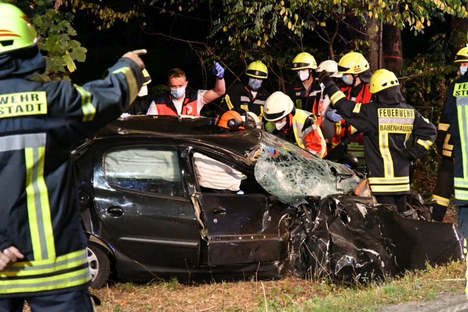 Einsatzkräfte stehen vor einem der verunfallten Autos.