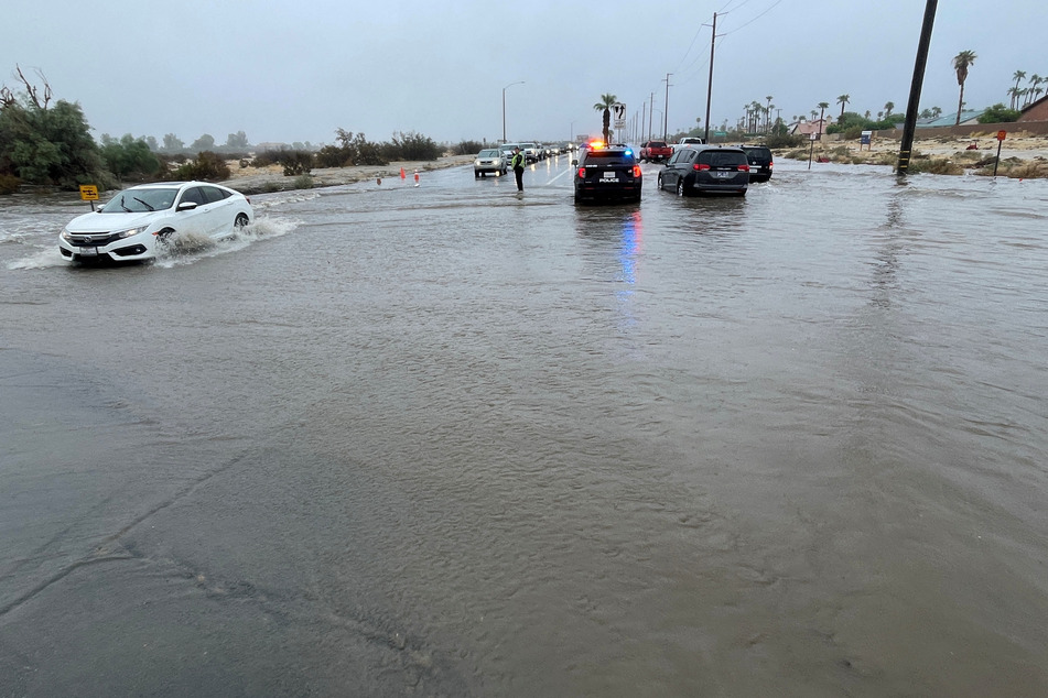 An intersection in Palm Springs is flooded as Tropical Storm Hilary approaches California.