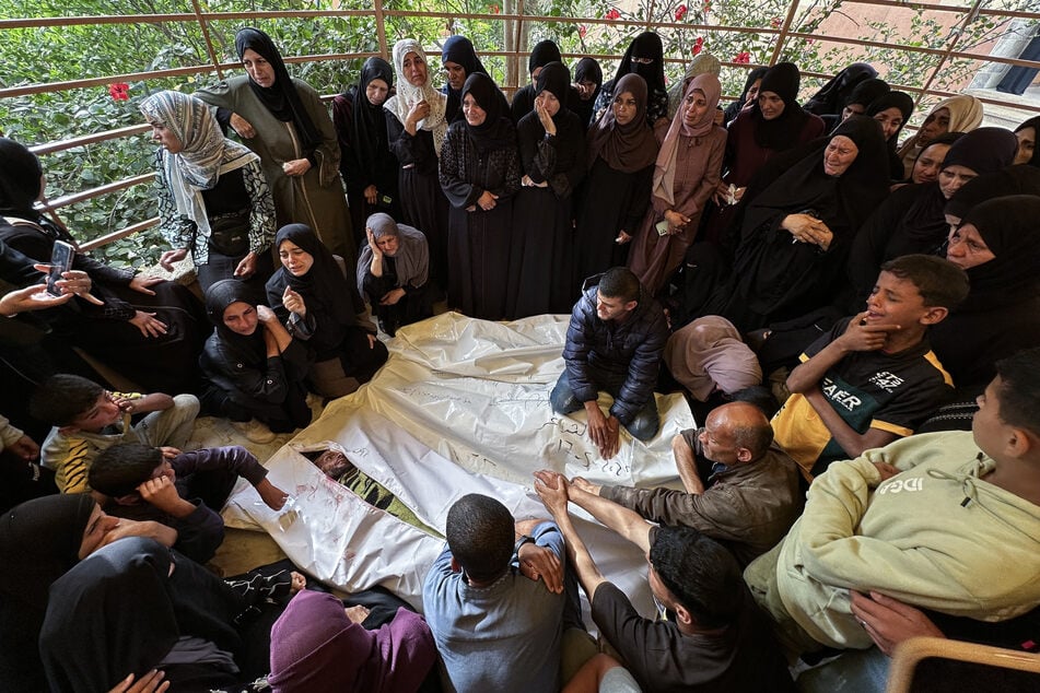 Palestinians mourn by the bodies of relatives killed in Israeli strikes on displacement tents in the westward Mawasi area, at the Nasser hospital in Khan Younis in the southern Gaza Strip, on May 18, 2025.