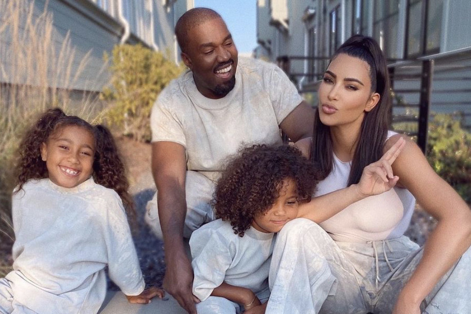 Kim Kardashian (r) and Kanye West (m) with two of their children, North (l) and Saint (r).