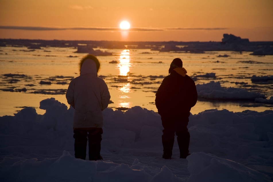Inupiaq subsistence whalers look out as the mid-day sun follows the horizon offshore from Utqiagvik on the Arctic coast of Alaska.
