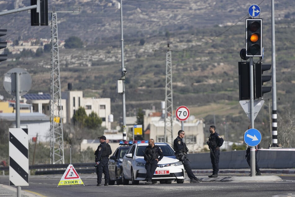 Nach einem Anschlag mit drei Toten haben israelische Polizisten eine Hauptstraße gesperrt.