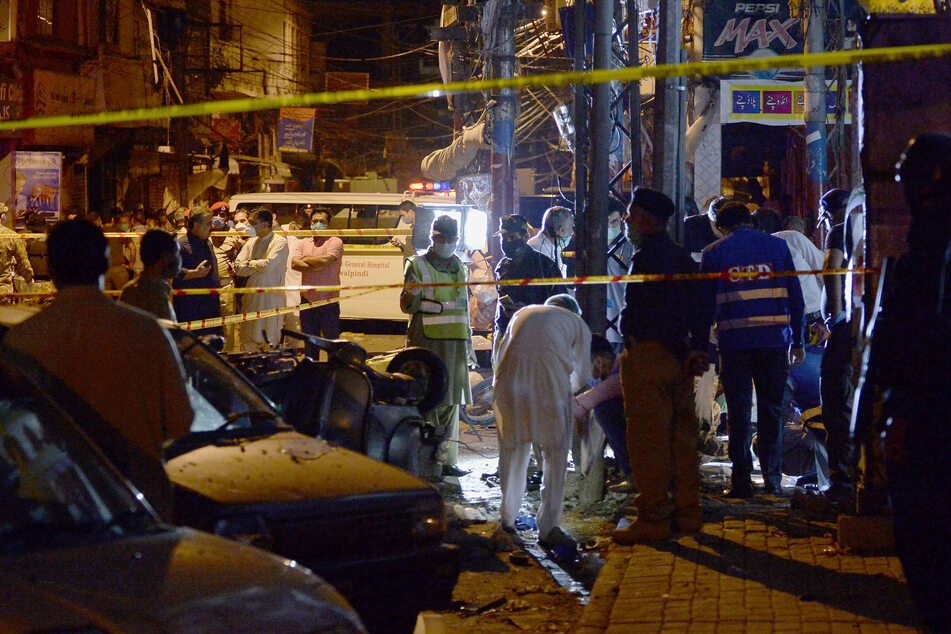Pakistans Sicherheitsbeamte untersuchen den Ort einer Bombenexplosion, die den Basar in Rawalpindi zerstörte.