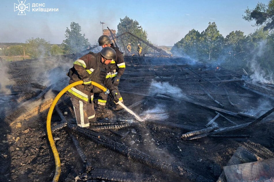 Ukrainian rescuers extinguishing a fire at the site of an air attack in Kyiv region on May 12, 2026.