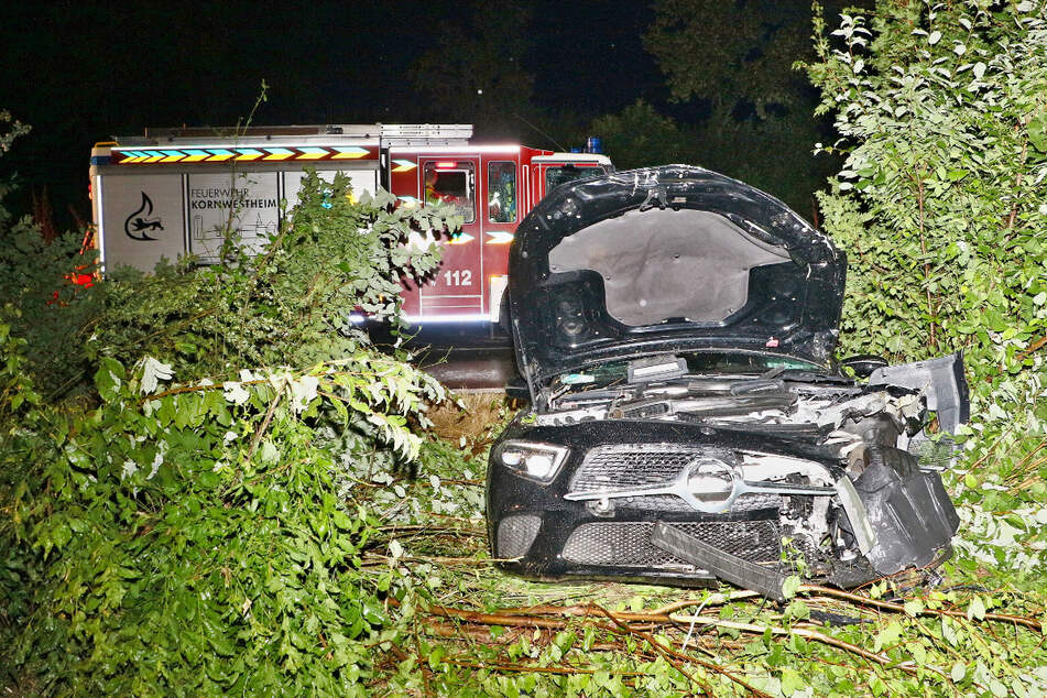 Feuerwehrleute mussten den stark beschädigten Mercedes CLS aus dem Gebüsch bergen.