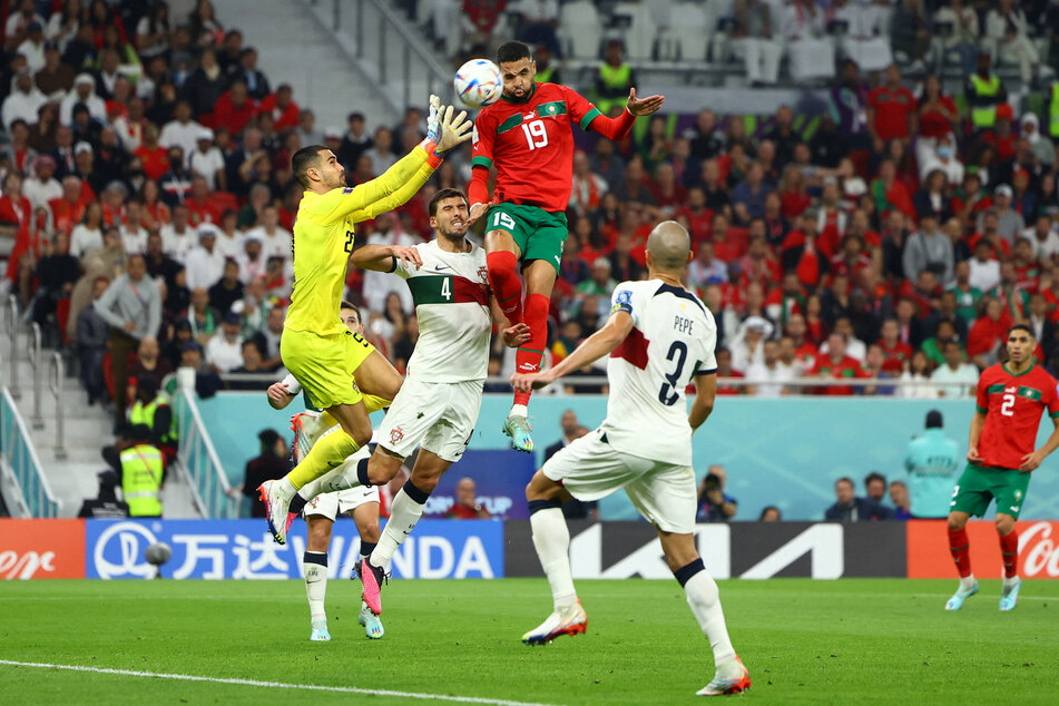 Morocco's Youssef En-Nesyri scores against Portugal goalkeeper Diogo Costa during their 2022 World Cup quarterfinal game.