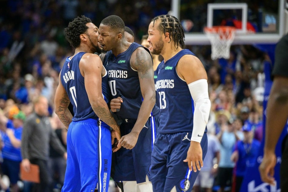 Mavs forward Dorian Finney-Smith (c.) celebrates with his teammates after their win over the Suns.