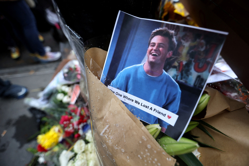 Fans gathered outside the Friends apartment in New York to leave tributes to Matthew Perry.