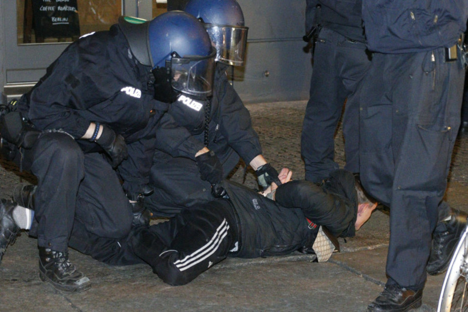 Polizisten nehmen eine Person fest, die sich gegen die Räumung zur Wehr gesetzt hat.