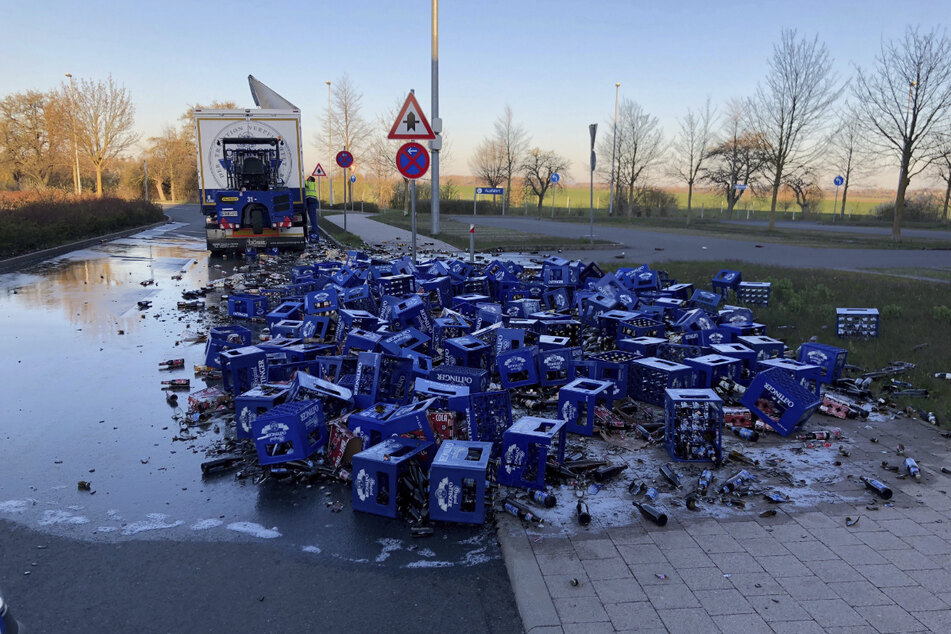 Zahlreiche Kisten und kaputte Bierflaschen liegen auf der Straße verteilt.