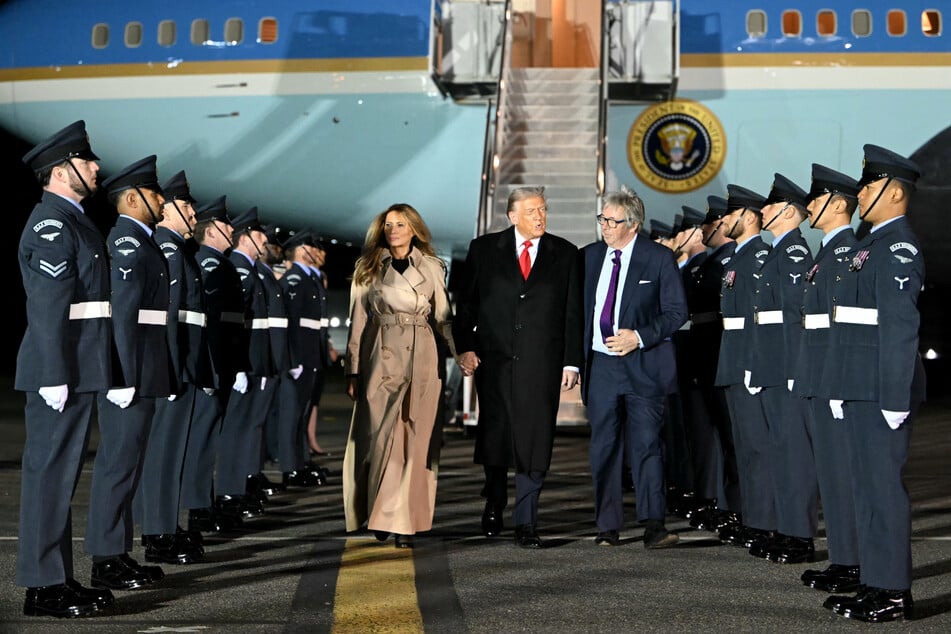 President Donald Trump (c.) and First Lady Melania Trump disembark from Air Force One after landing at Stansted Airport, eastern England, on Tuesday, on the first day of a two-day visit to the UK.