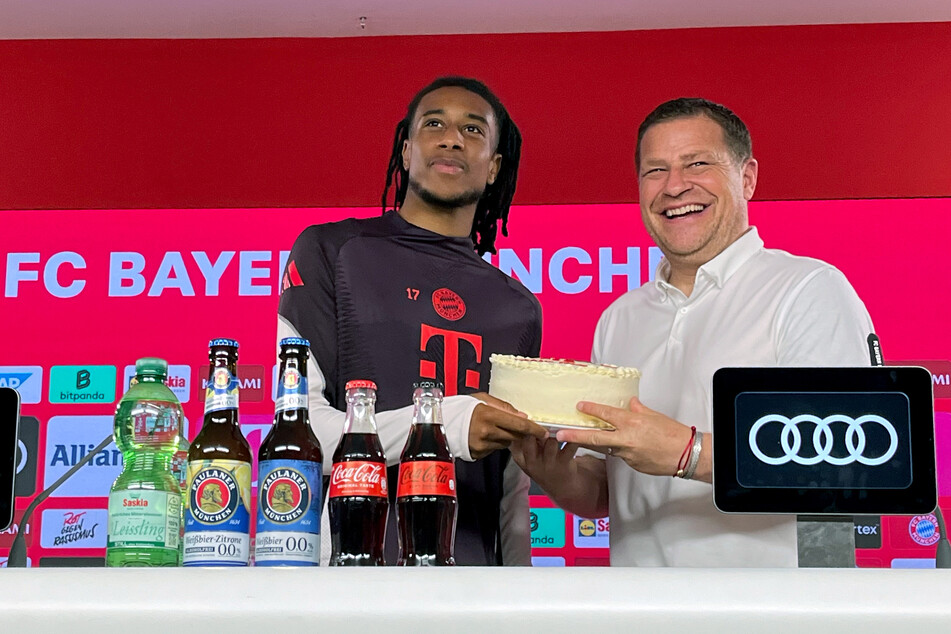 Bayern-Boss Max Eberl (50) mit Neuzugang Michael Olise (22) und einer Torte für den Franzosen.