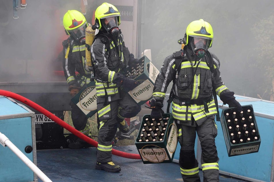 Die Feuerwehrleute räumten während des Einsatzes mehrere Kästen Bier vom Laster.