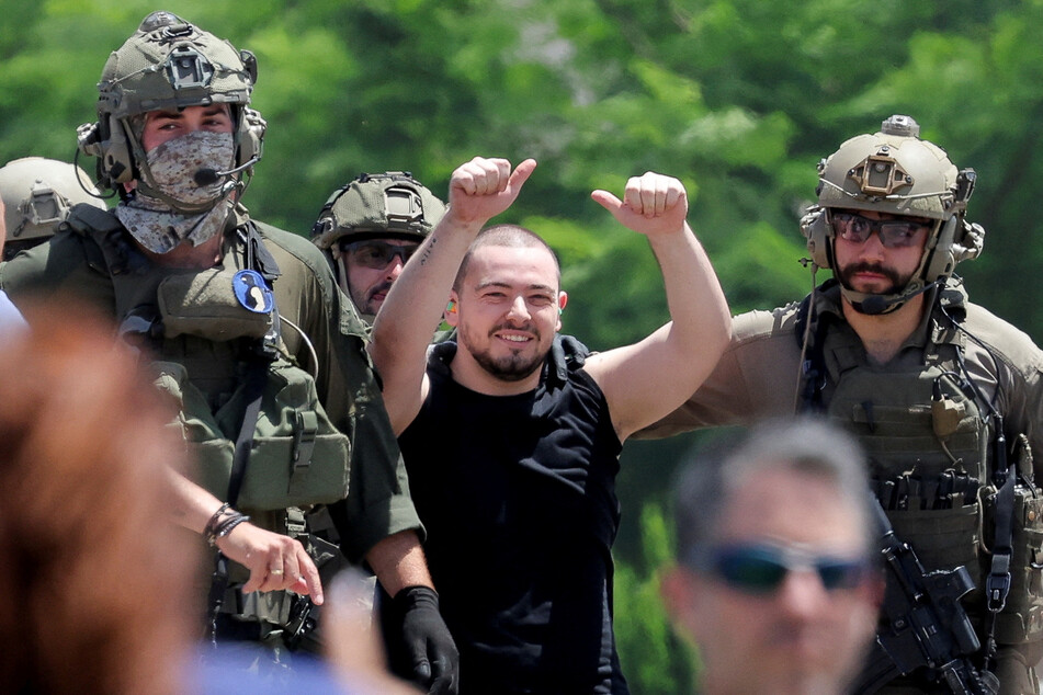 Former hostage Almog Meir Jan is escorted by Israeli military forces after his release.