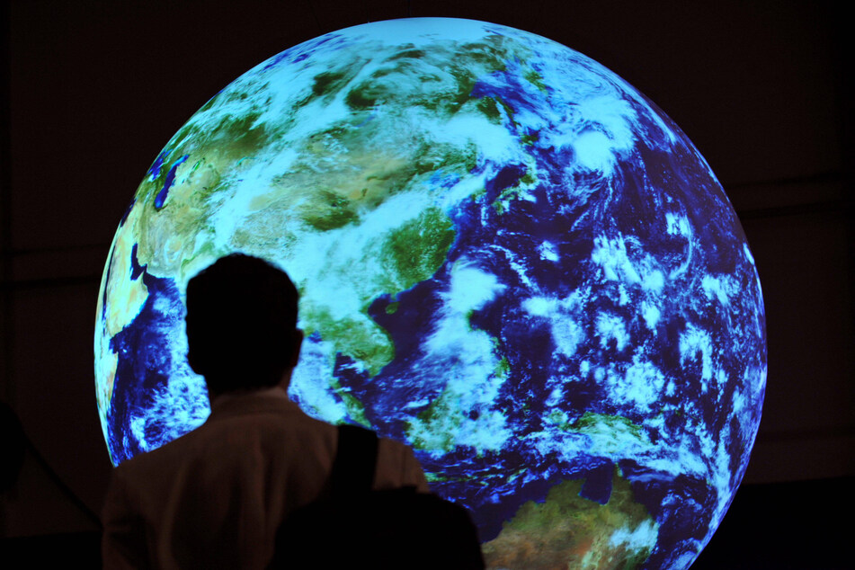 A man walks past an Earth model at the conference hall of the 2009 United Nations Climate Change Conference in Copenhagen.