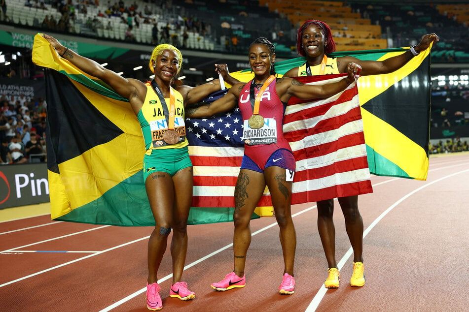Sha'carri Richardson celebrates after winning gold alongside silver medalist Shericka Jackson of Jamaica and bronze medalist Shelly-Ann Fraser-Pryce of Jamaica.