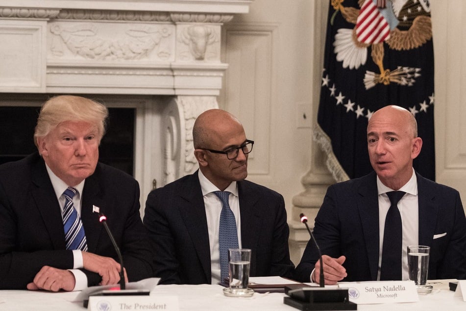 Donald Trump (L) and Microsoft CEO Satya Nadella (C) listen to Amazon CEO Jeff Bezos (R) during an American Technology Council roundtable at the White House in Washington, DC, on June 19, 2017.