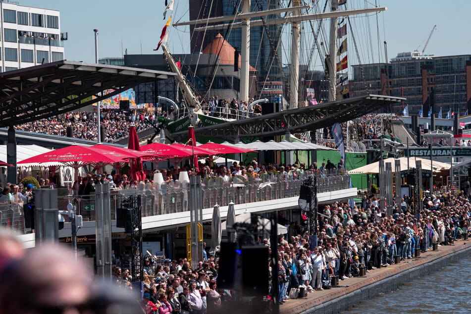 Die Schaulustigen tummeln sich am Hafen, um einen Blick auf die Parade zu erhaschen.