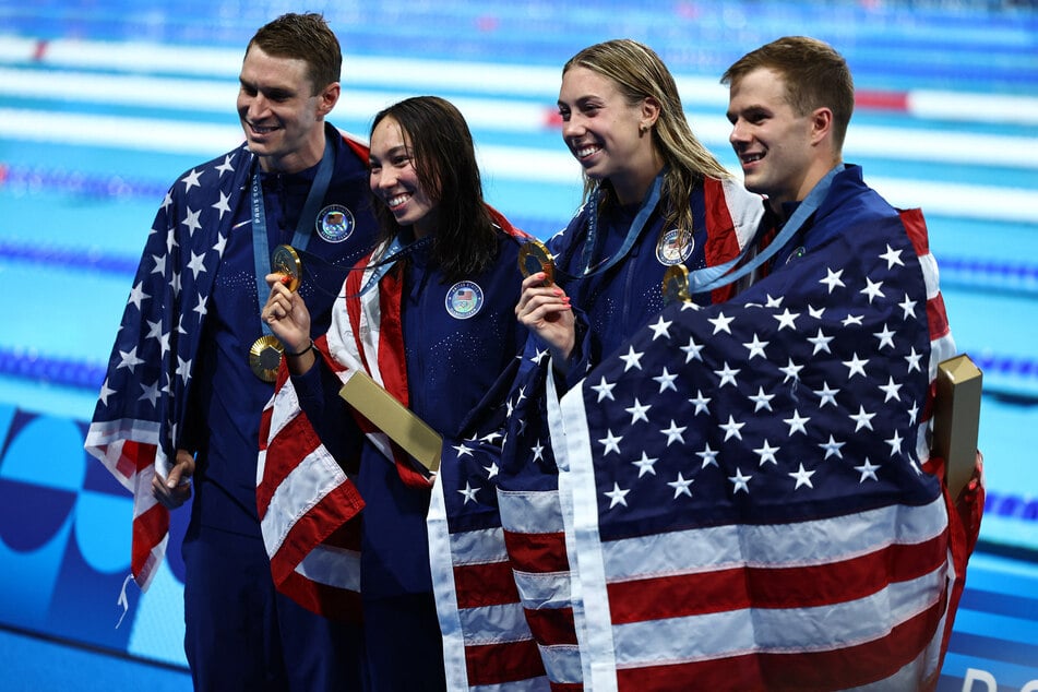 From l. to r.: Ryan Murphy, Torri Huske, Gretchen Walsh, and Nic Fink of USA pose with their medals after winning gold in the Paris Olympics 4x100m mixed medley final.