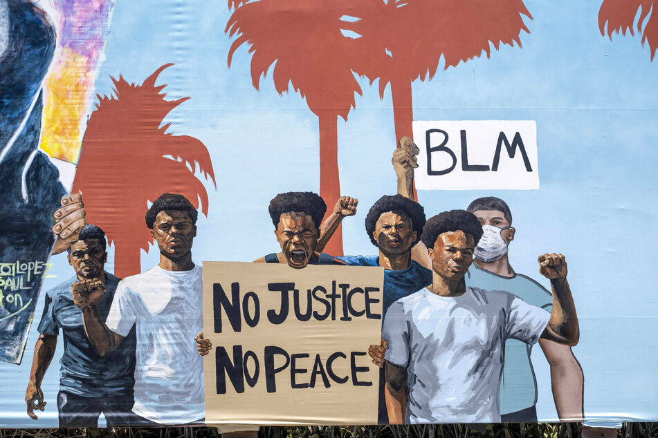 The mural also features depictions of Black Lives Matter protesters.