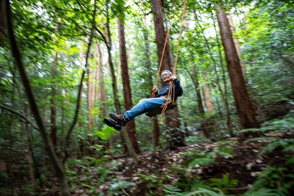 Masana Izawa playing on a swing in his forest in Sakuragawa, Ibaraki Prefecture, Japan.