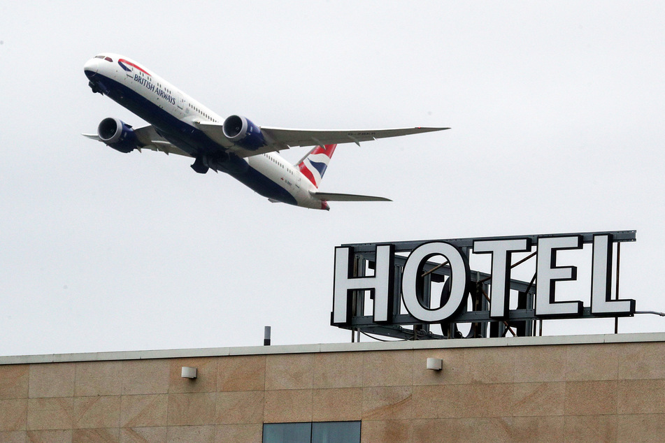 Ein "British Airways"-Flugzeug fliegt über einem Hotel vorbei.
