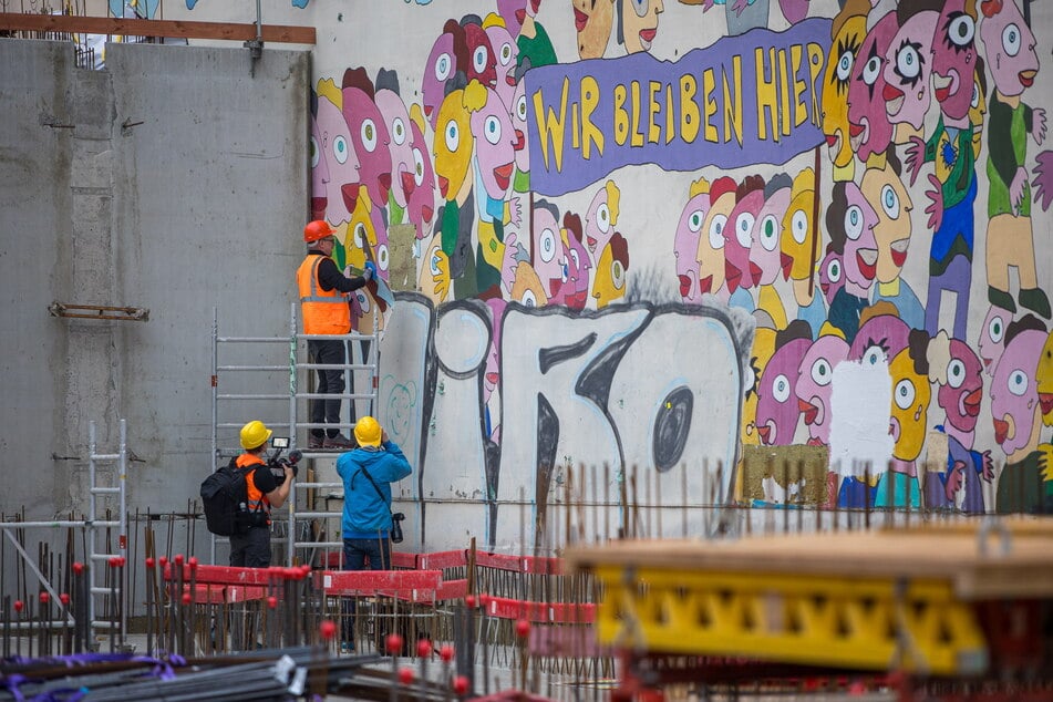 Von einem kleinen Gerüst aus schnitt der Künstler auf der Baustelle am Leipziger Brühl Bildteile von der Wand.